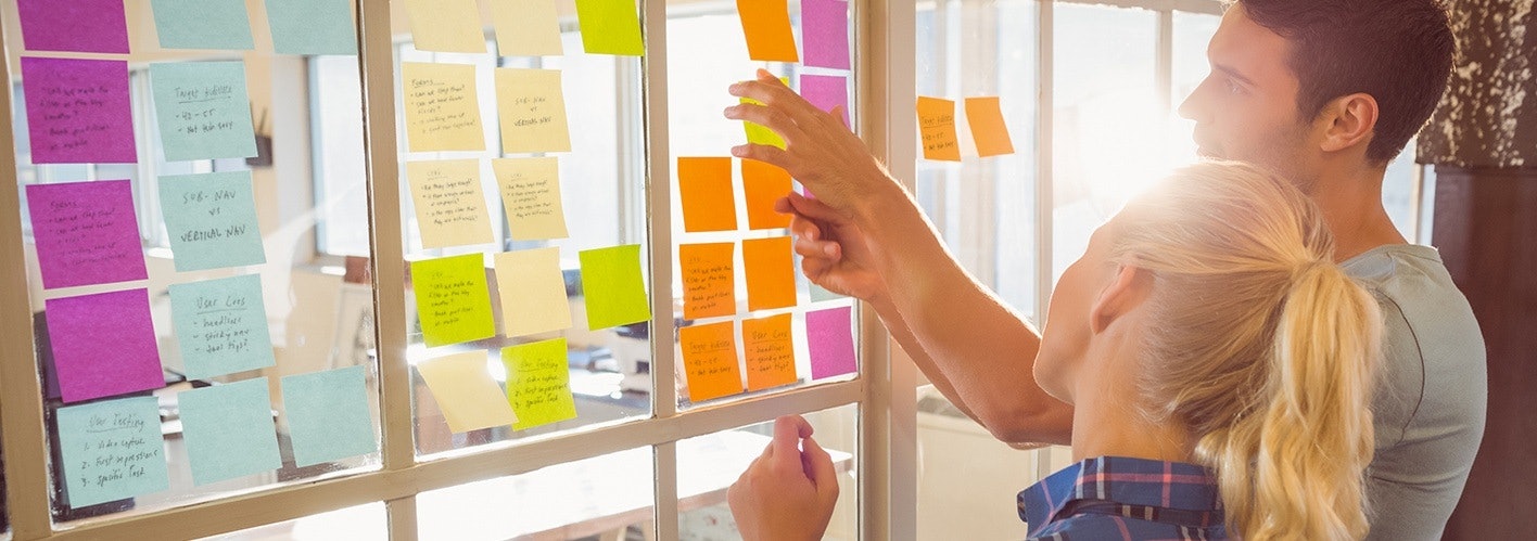 two marketers looking at various post-it notes